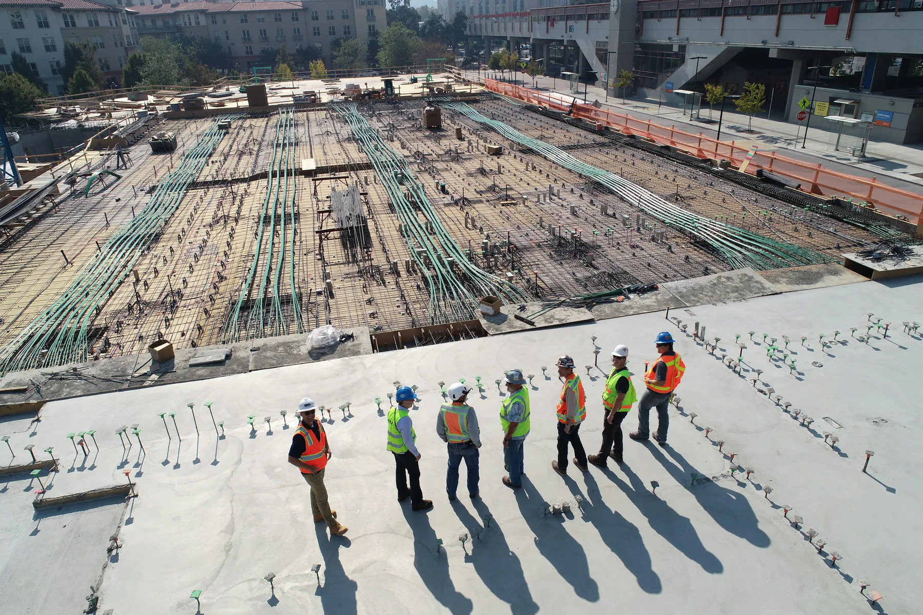 Construction team reviewing work across a large concrete structure